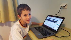 למידה מרחוק ילד בחולצה לבנה ליד המחשב שלו- כל הזכויות שמורות ללחישות לילה להעצמת ילדים